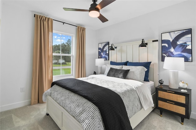 bedroom featuring baseboards, light colored carpet, and ceiling fan