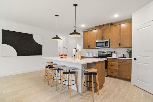 kitchen with brown cabinets, a kitchen breakfast bar, stainless steel appliances, and wood finish floors