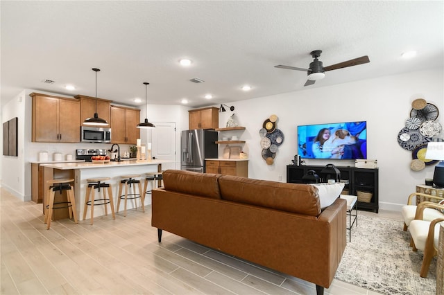 living area featuring recessed lighting, light wood-style floors, visible vents, and ceiling fan