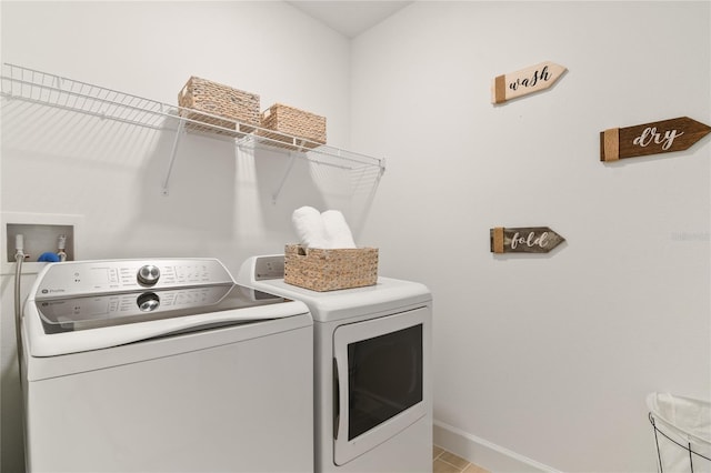 laundry area with baseboards, separate washer and dryer, and laundry area