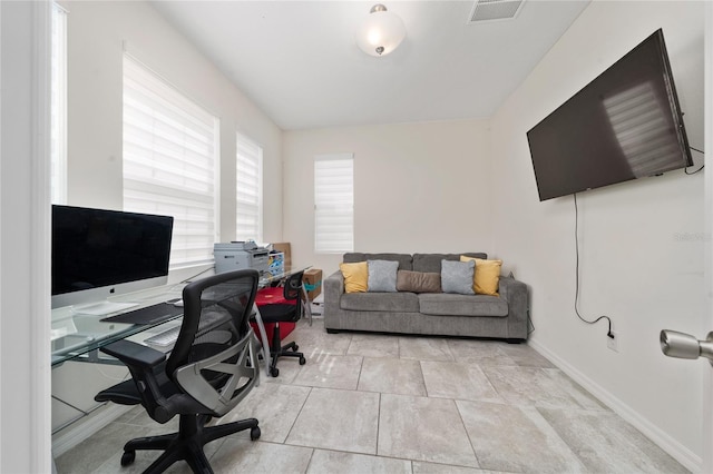 office featuring light tile patterned floors, visible vents, and baseboards