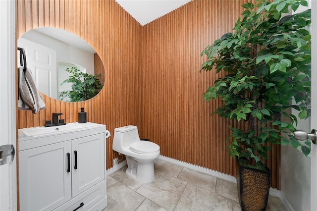 bathroom with vanity, toilet, and baseboards