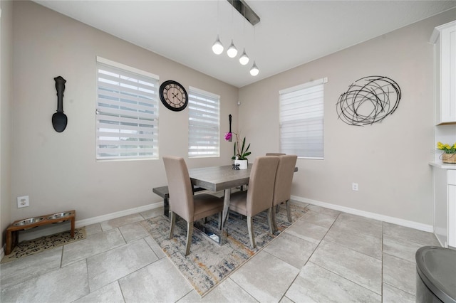 dining area with baseboards and light tile patterned flooring