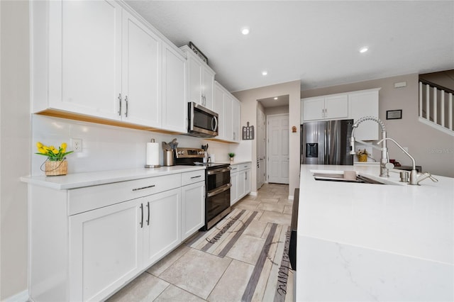 kitchen featuring a sink, white cabinets, recessed lighting, and stainless steel appliances