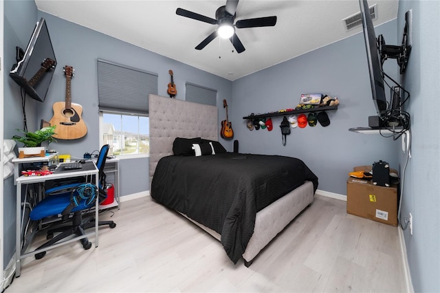 bedroom with visible vents, ceiling fan, baseboards, and wood finished floors