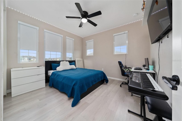 bedroom with light wood-style flooring, baseboards, and ceiling fan