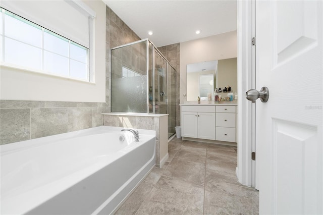 bathroom with vanity, a bath, and a stall shower