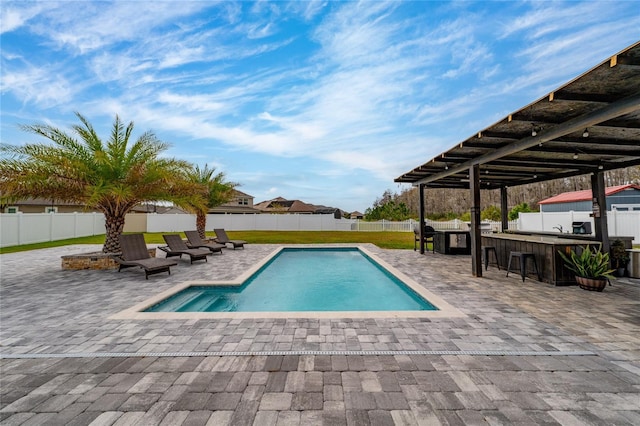 view of swimming pool featuring a patio area, a fenced backyard, and outdoor dry bar