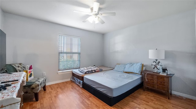 bedroom featuring light wood-style flooring, baseboards, and ceiling fan