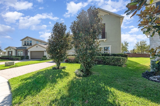 view of front of property with a front yard, decorative driveway, and stucco siding