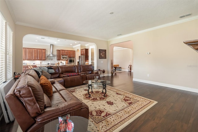 living area with arched walkways, visible vents, dark wood-type flooring, and ornamental molding