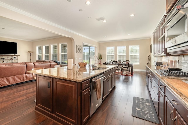 kitchen with a sink, stainless steel appliances, ornamental molding, and dark wood-style flooring