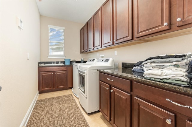 laundry area featuring independent washer and dryer, a sink, cabinet space, light tile patterned flooring, and baseboards