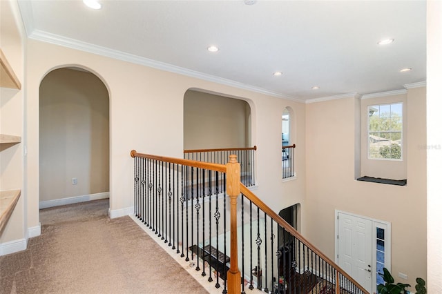 corridor with baseboards, carpet floors, an upstairs landing, and ornamental molding