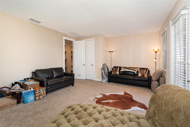 living area featuring visible vents and carpet