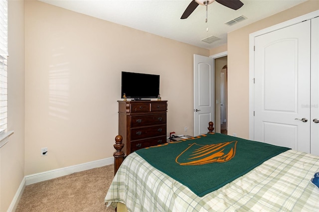 carpeted bedroom with baseboards, visible vents, arched walkways, ceiling fan, and a closet