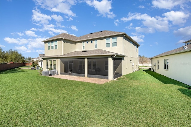 back of house featuring stucco siding, a lawn, central AC, and a sunroom