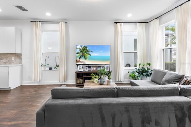 living area with dark wood-style floors, visible vents, recessed lighting, and baseboards