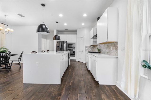 kitchen with tasteful backsplash, visible vents, light countertops, appliances with stainless steel finishes, and dark wood-style flooring