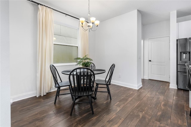 dining space featuring dark wood finished floors, a chandelier, and baseboards