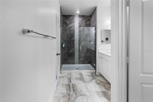 bathroom featuring a shower stall, baseboards, vanity, marble finish floor, and a textured ceiling