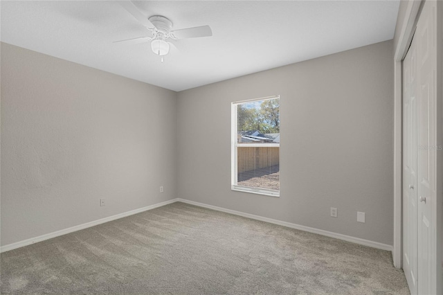 carpeted empty room with baseboards and ceiling fan