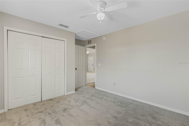 unfurnished bedroom featuring visible vents, a closet, carpet, baseboards, and attic access