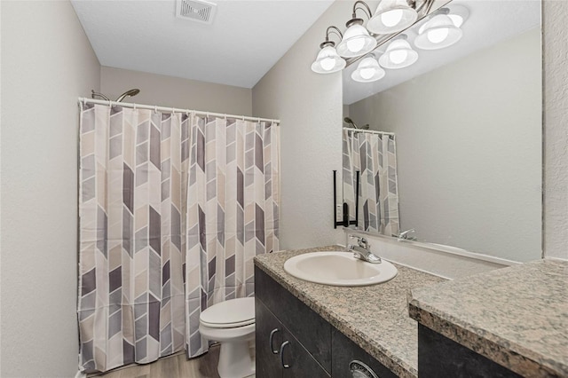 bathroom featuring vanity, wood finished floors, visible vents, toilet, and a chandelier