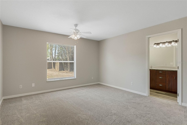 spare room with baseboards, light colored carpet, and ceiling fan