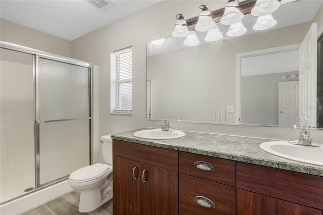 full bathroom with a sink, visible vents, a stall shower, and double vanity