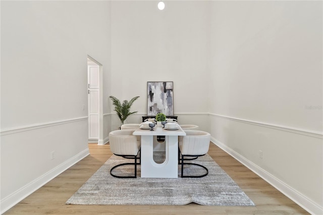 dining space with baseboards and light wood-style floors