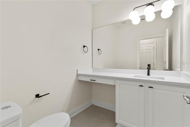 bathroom with toilet, vanity, and baseboards