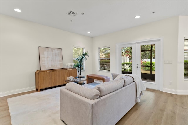 living area featuring recessed lighting, visible vents, light wood-style flooring, and french doors