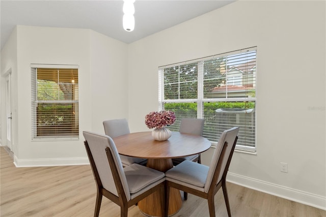 dining room featuring baseboards and light wood finished floors