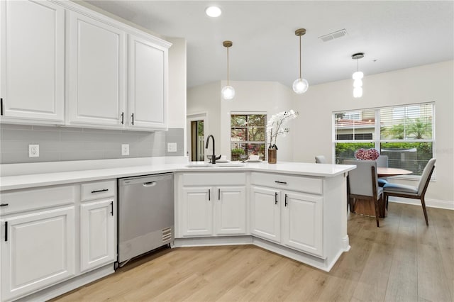 kitchen featuring visible vents, a peninsula, a sink, light countertops, and dishwasher