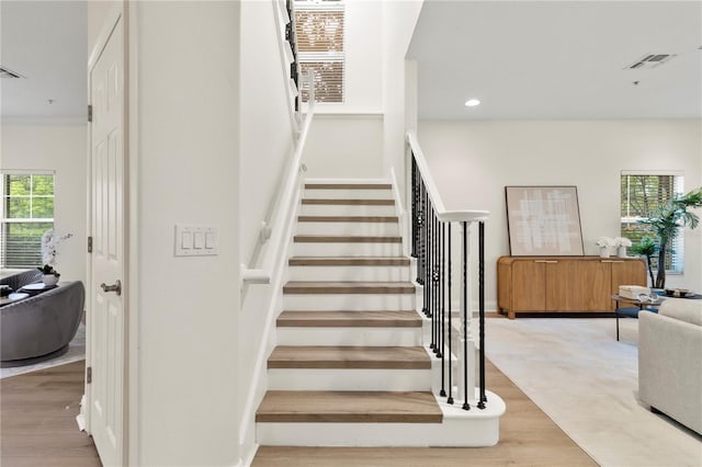 stairs featuring recessed lighting, wood finished floors, and visible vents