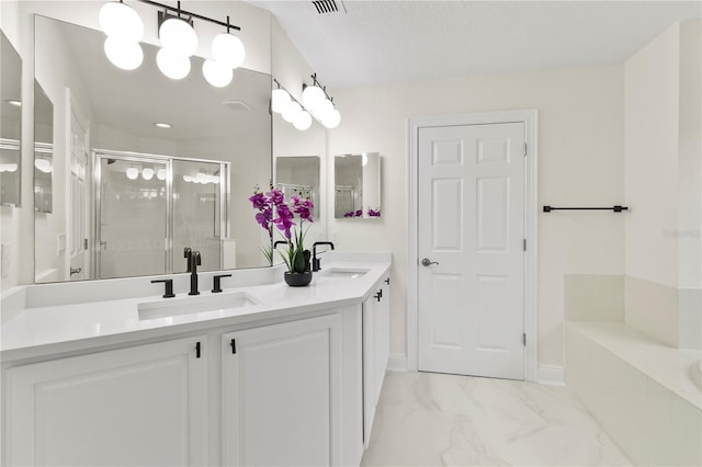 full bathroom featuring a shower stall, double vanity, marble finish floor, and a sink