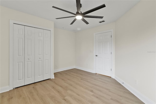 unfurnished bedroom featuring a closet, visible vents, baseboards, and light wood-style floors