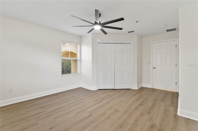 unfurnished bedroom with visible vents, baseboards, a closet, and light wood finished floors