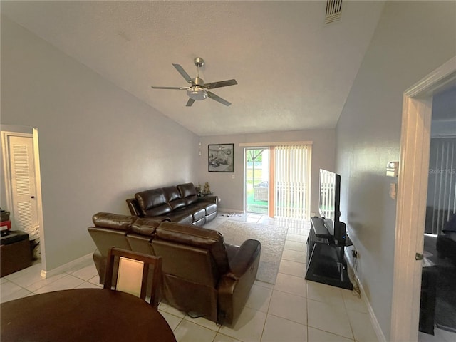 living area with visible vents, a ceiling fan, light tile patterned flooring, baseboards, and vaulted ceiling