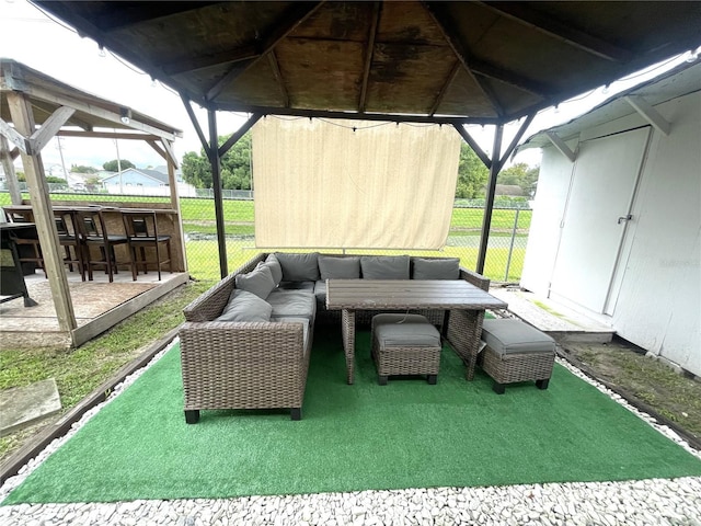 view of patio featuring a gazebo, outdoor dry bar, outdoor lounge area, and fence