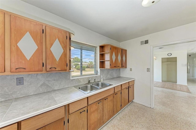 kitchen featuring visible vents, open shelves, a sink, decorative backsplash, and brown cabinets