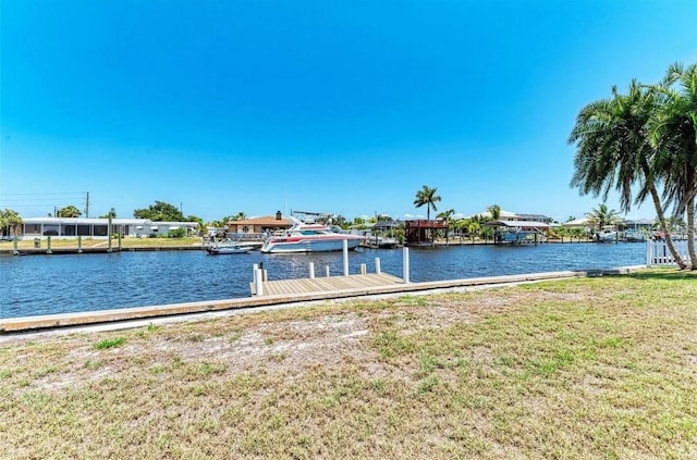 view of dock with a water view and a lawn