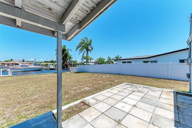 view of yard featuring fence, a patio area, and a water view