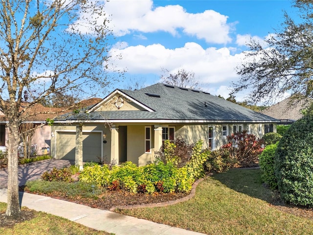 single story home with a shingled roof, a front yard, stucco siding, a garage, and driveway