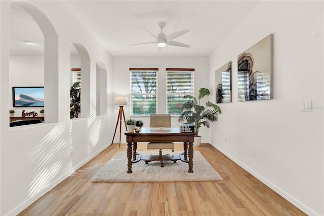 home office featuring a ceiling fan, wood finished floors, and baseboards