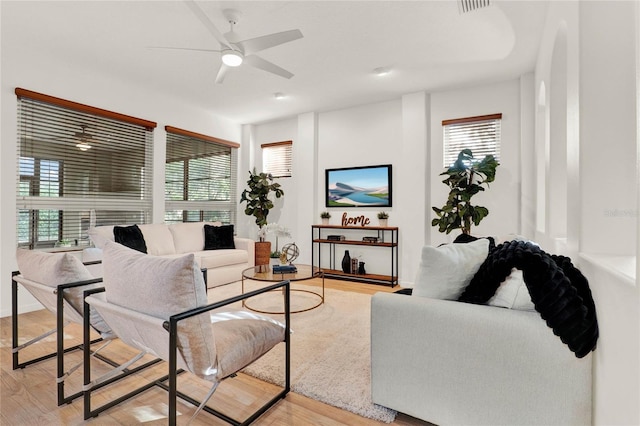 living room with light wood finished floors and a ceiling fan