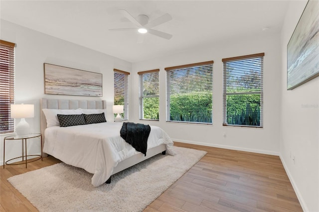 bedroom featuring baseboards, ceiling fan, and light wood finished floors