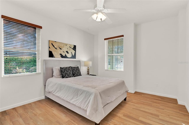 bedroom featuring light wood-style floors, baseboards, and ceiling fan