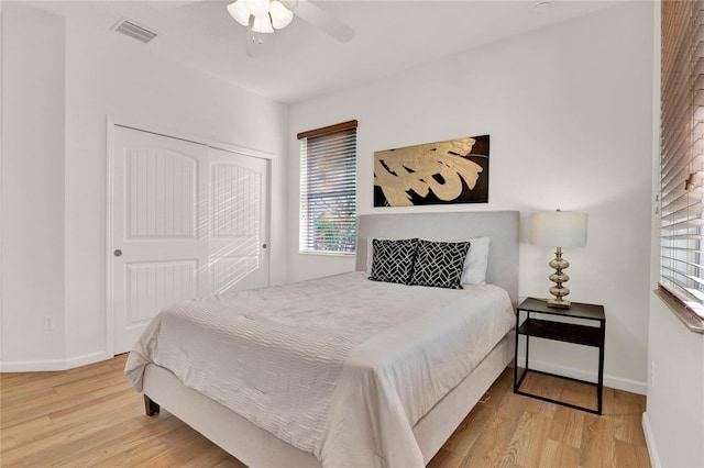 bedroom featuring a closet, visible vents, baseboards, and wood finished floors